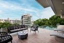 Terrasse avec piscine de l’appartement témoin, vue sur la ville