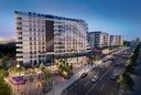 Avenue bordée de commerces à la tombée de la nuit (rendu 3D)