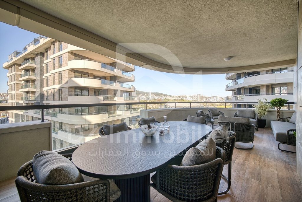 Terrasse avec table à manger d’un appartement témoin et vue sur les immeubles voisins