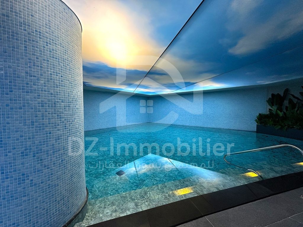Piscine intérieure du spa, bassin et plafond décoré d’un ciel