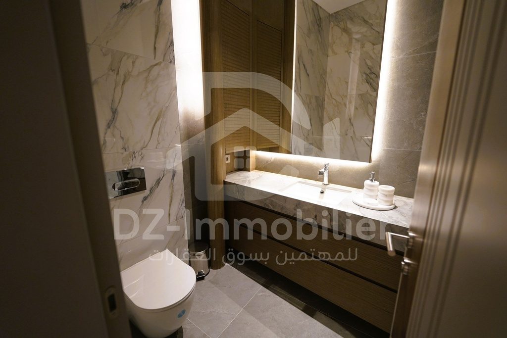 Salle de bain du 1+1 avec vasque et revêtement en pierre claire